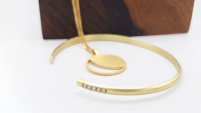 Hemi & Zo gold gold Moon Phase necklace and a gold bangle with four diamonds, symbolizing cherished family members or personal milestones, showcased next to a hand made wooden box