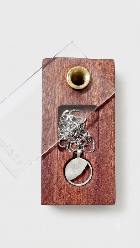 Silver necklace with a moon phase pendant in a wooden box against a light gray background