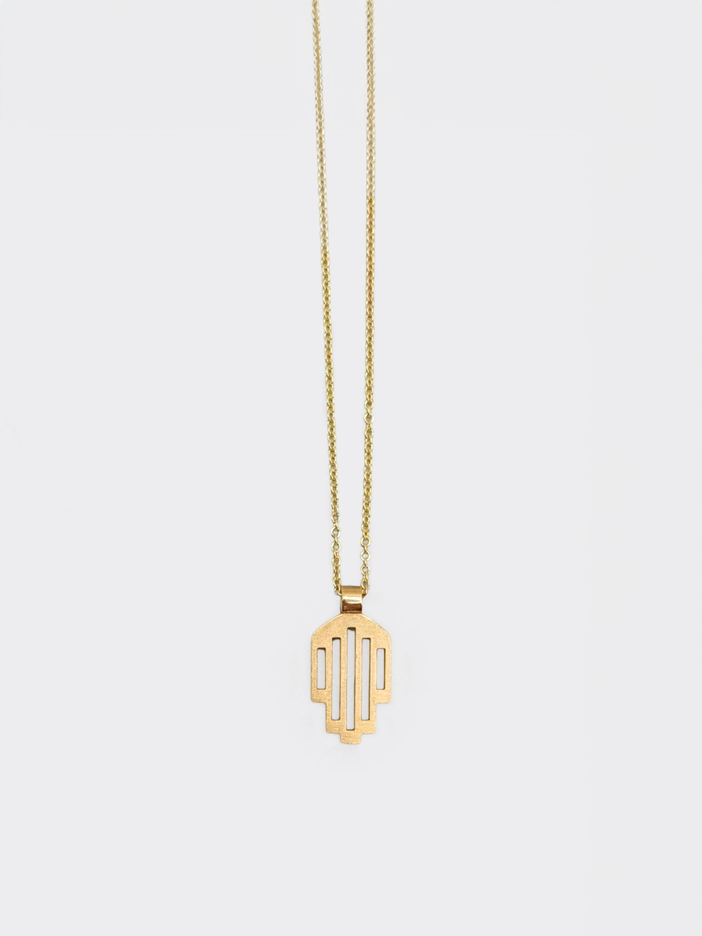 Hemi and Zo  Minimalist hamsa pendant necklace in gold on a light gray background