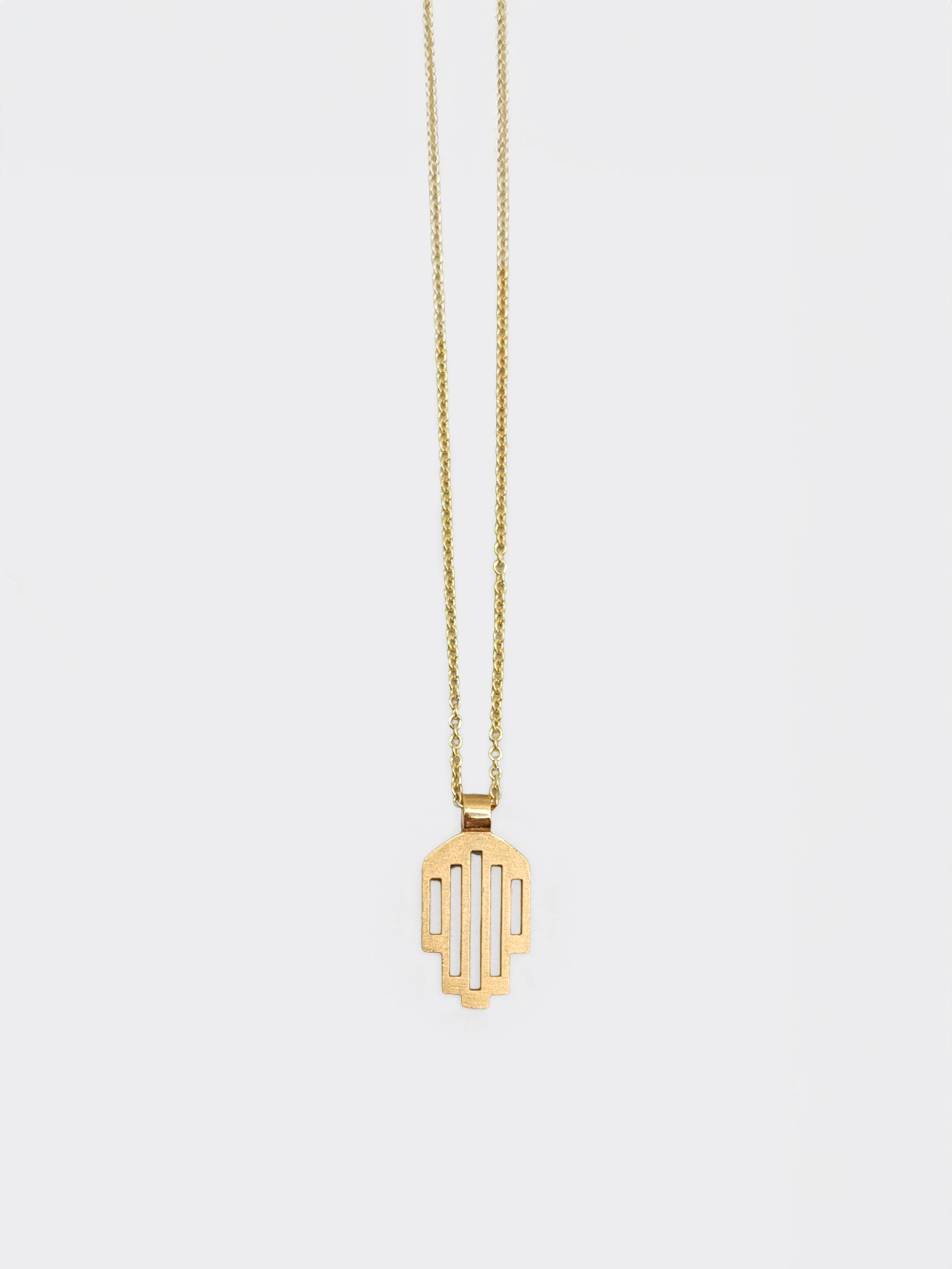 Hemi and Zo  Minimalist hamsa pendant necklace in gold on a light gray background