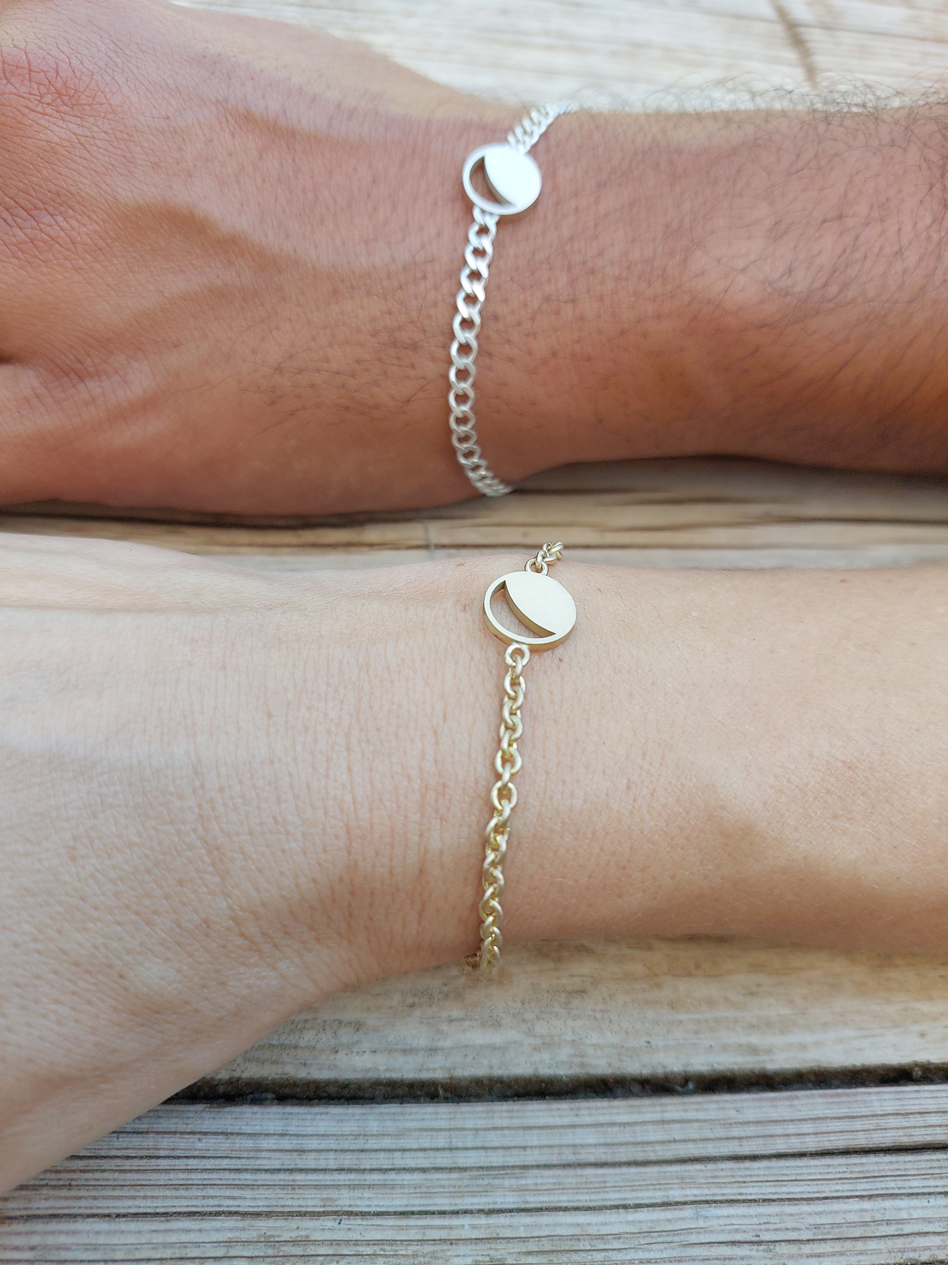 Two Hemi & Zo Moon Phase bracelets, a gold bracelet on a woman’s hand and a silver bracelet on a man's hand