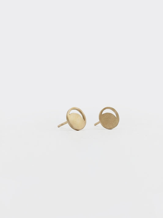 Pair of gold moon phase earrings on a light gray background