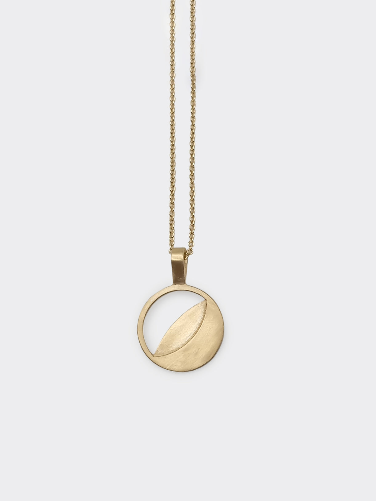 A gold necklace with a round multy date moon phase pendant on a chain
