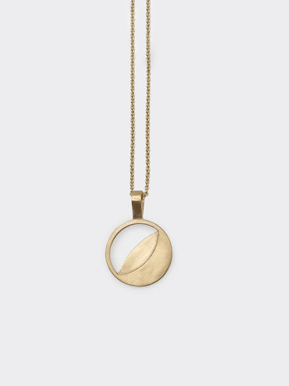 A gold necklace with a round multy date moon phase pendant on a chain