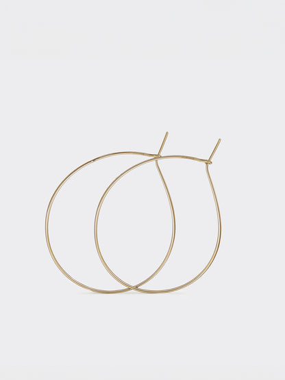 Gold teardrop hoop earrings on a light gray background