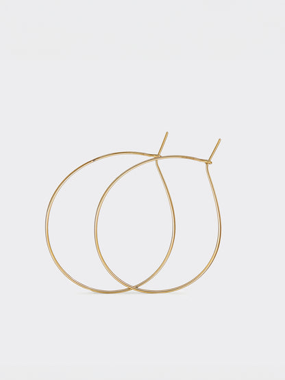Gold teardrop hoop earrings on a light gray background