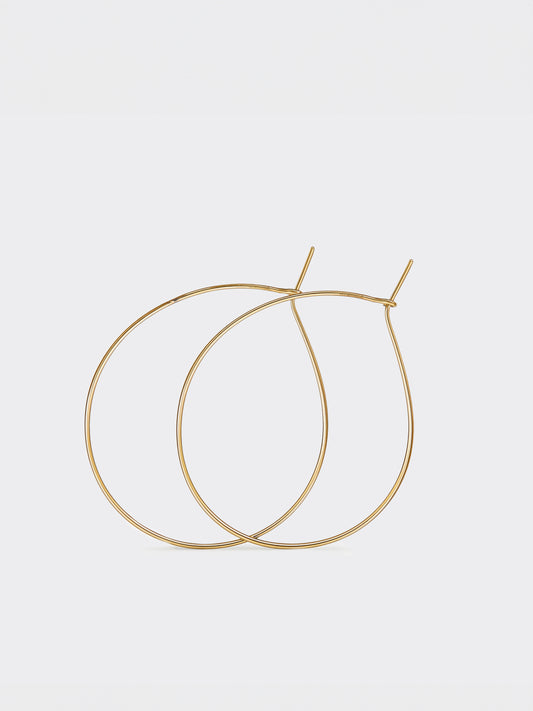 Gold teardrop hoop earrings on a light gray background